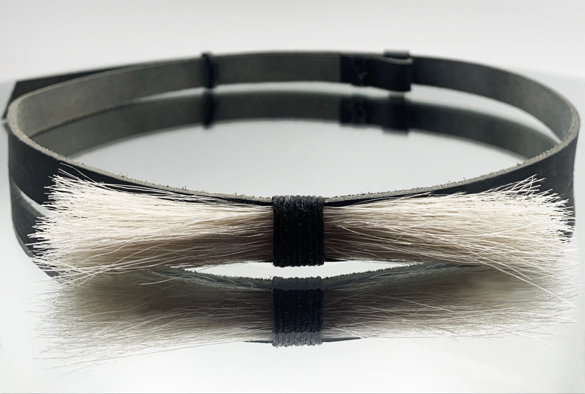 Black leather hat belt with horse hair on a white background